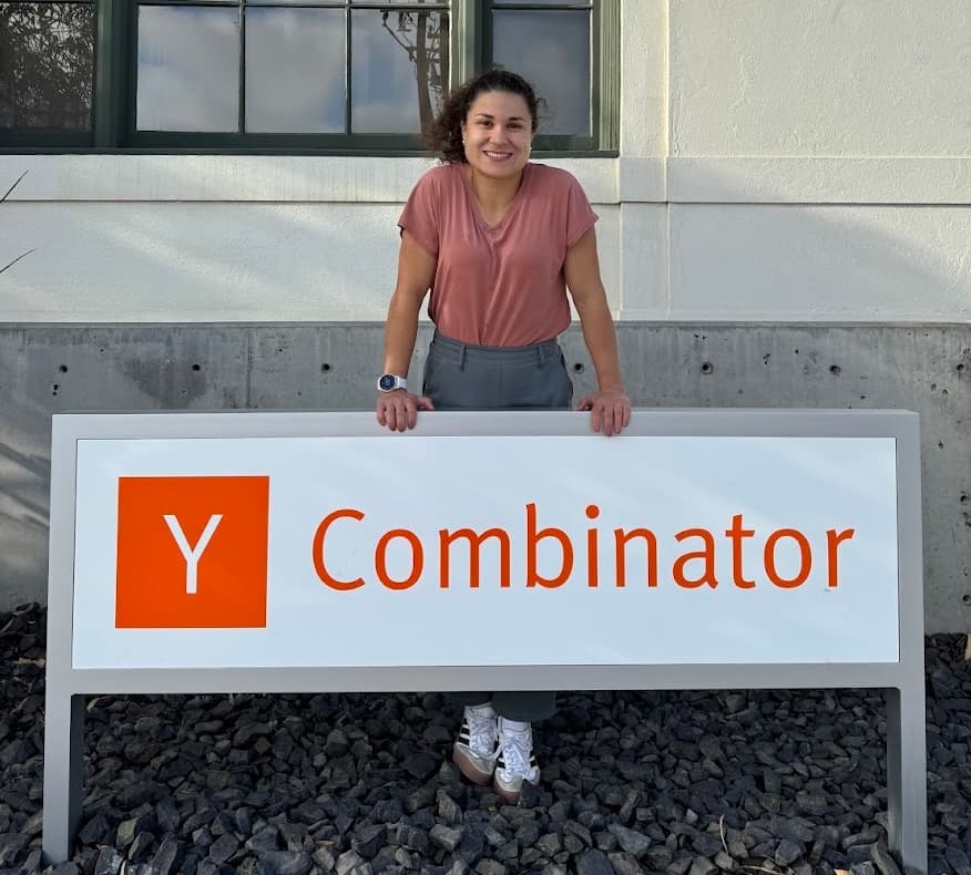 Anaïs Howland standing behind the Y Combinator sign